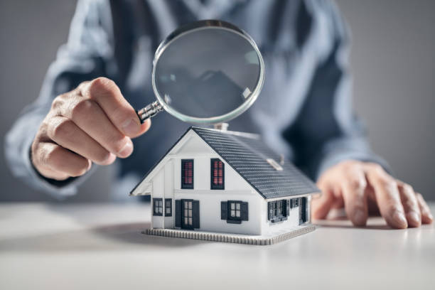 Image of a magnifying glass being held over a miniature house model